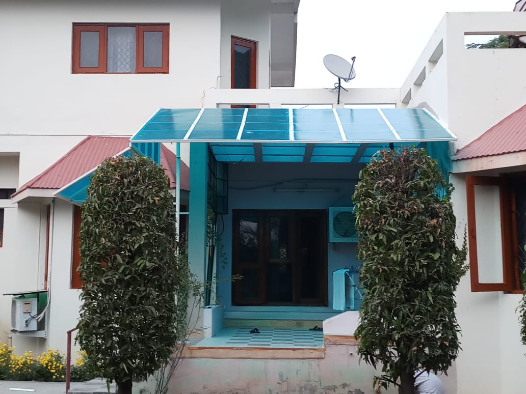 Blue polycarbonate canopy covering a building entrance